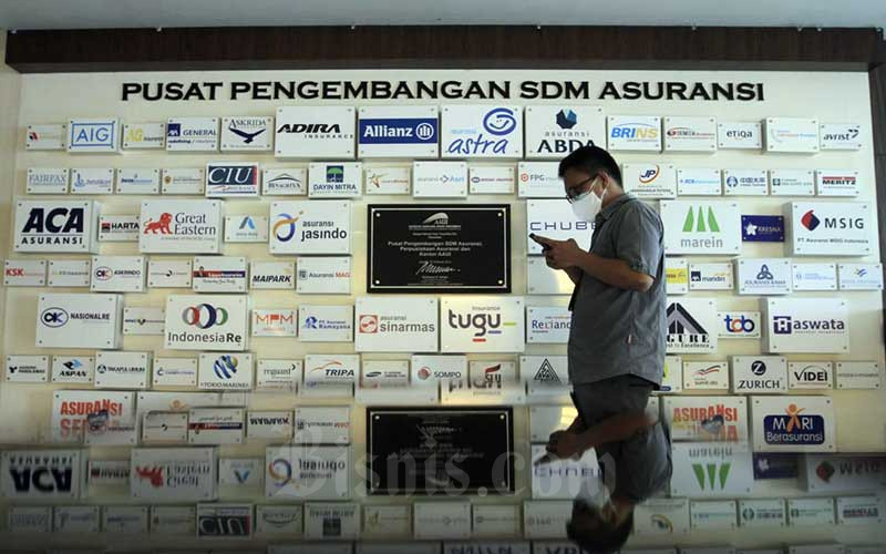 Karyawan beraktifitas di dekat deretan logo-logo perusahaan asuransi di Kantor Asosiasi Asuransi Umum Indonesia (AAUI) di Jakarta, Selasa (22/9/2020). Bisnis - Himawan L Nugraha
