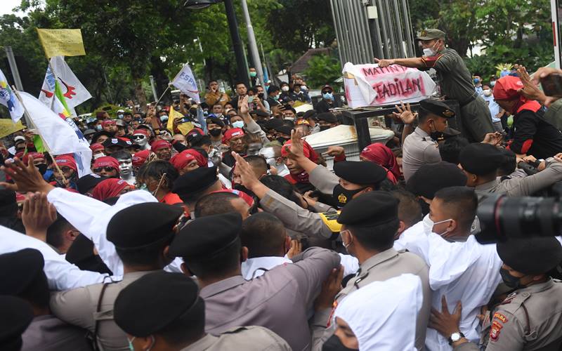 Sejumlah buruh mencoba menerobos pagar saat melakukan aksi unjuk rasa menolak upah minimum provinsi (UMP) di depan Balaikota DKI Jakarta, Senin (29/11/2021). Mereka menolak UMP DKI Jakarta yang hanya naik Rp37.749 atau sekitar 0,8 persen saja dibandingkan tahun lalu. ANTARA FOTO/Akbar Nugroho Gumay - aww.
