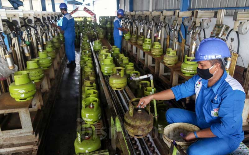 Petugas melakukan tahap pengisian LPG pada tabung gas 3kg di SPBE Srengseng, Jakarta, Senin (1/2/2021). Bisnis - Eusebio Chrysnamurti