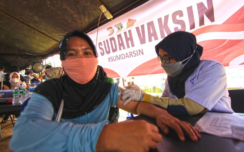 Seorang warga tengah disuntik vaksin dalam kegiatan Sumbar Sadar Vaksin (Sumdarsin) di Stadion GOR Agus Salim Padang.  - Bisnis/Noli Hendra