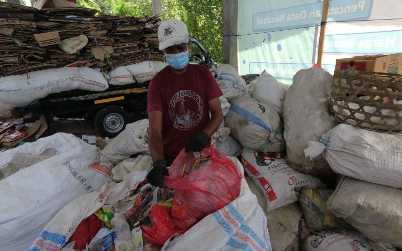 Wayan Sukadana memilah sampah plastik dari dalam karung.  - Feri Kristianto/Bisnis.com