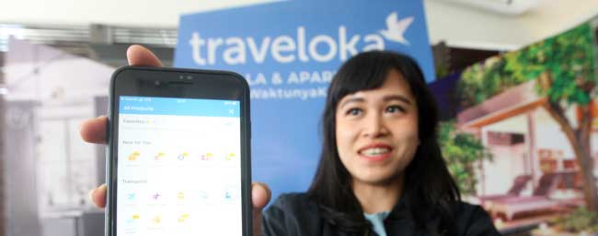 Model menunjukan aplikasi Traveloka di Jakarta. Bisnis - Dedi Gunawan