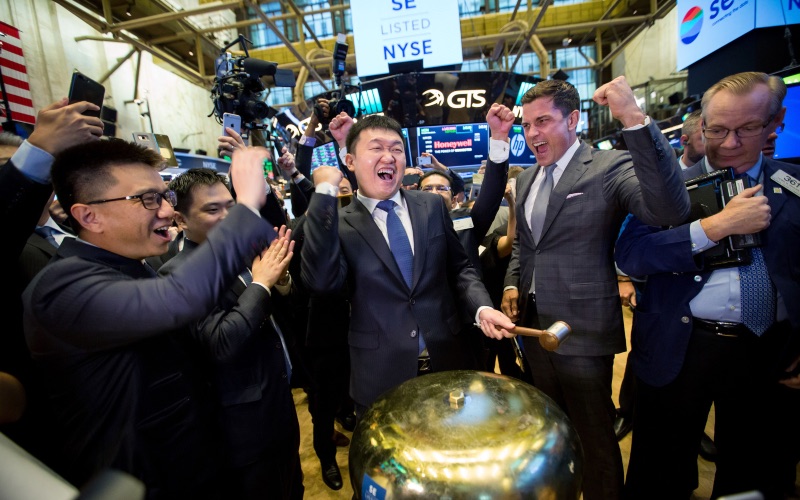 Chairman dan CEO Sea Ltd. Forrest Li (tengah) merayakan listing perusahaan teknologi tersebut di New York Stock Exchange (NYSE), AS, Jumat (20/10/2017). - Bloomberg/Michael Nagle