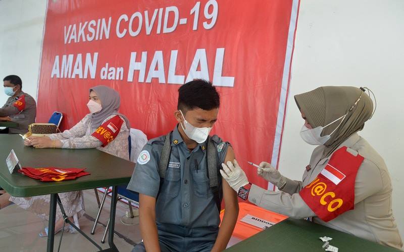 Petugas kesehatan menyuntikkan vaksin COVID-19 kepada seorang pelajar di gedung Taman Budaya, Banda Aceh, Aceh, Senin (6/12/2021). Pemerintah akan melakukan vaksinasi COVID-19 dosis ketiga atau booster/penguat secara paralel pada Januari 2022 kepada masyarakat secara gratis dan sebagian lainnya berbayar. ANTARA FOTO/Ampelsa - wsj.