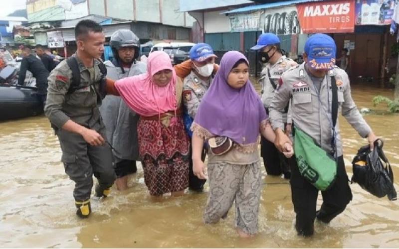 Anggota Polda Papua membantu warga terdampak banjir di kawasan Pasar Youtefa, Jumat (7/1/2022). - Antara