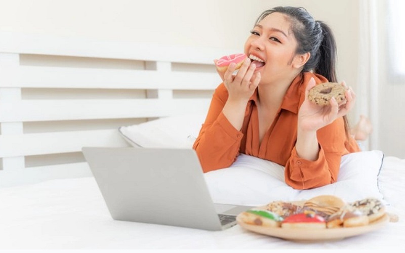 Ilustrasi perempuan makan sambil nonton yang bisa membuat berat badan naik - Freepik