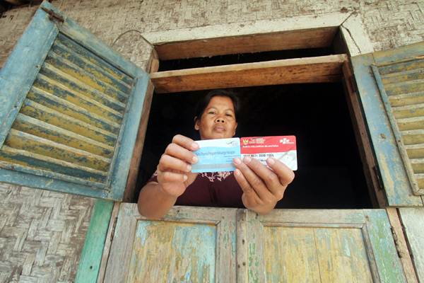 Pemerintah akan memberikan bantuan sosial atau bansos pada 2022. Warga menunjukan kartu peserta Program Keluarga Harapan (PKH) di Desa Gunung Sari, Citeureup, Bogor, Jawa Barat, Jumat (14/12/2018). - ANTARA/Yulius Satria Wijaya