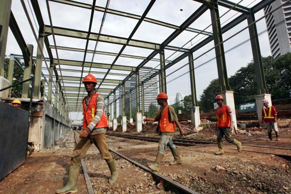 Pekerja berjalan melewati rel kereta api di Jakarta, Selasa (14/3). - JIBI/Dedi Gunawan