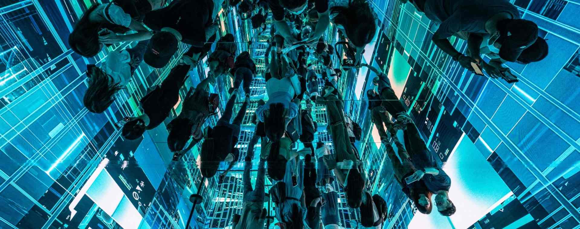 Refleksi pengunjung yang melihat instalasi seni imersif berjudul "Machine Hallucinations - Space: Metaverse" oleh Refik Anadol di Digital Art Fair Asia yang menampilkan seni digital dan NFT di Hong Kong. - Bloomberg/Lam Yik