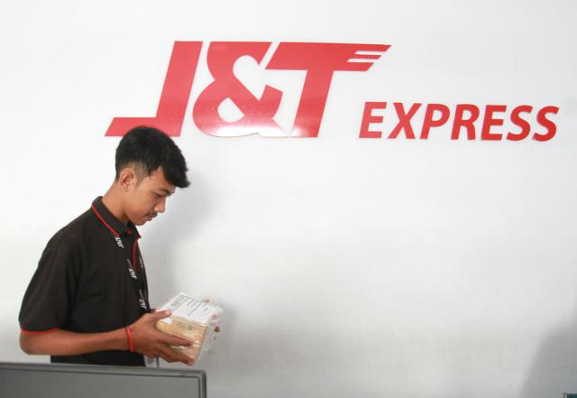 Karyawan pengiriman barang J&T memindahkan barang kiriman di Makassar, Sulawesi Selatan pekan lalu. Asosiasi Logistik dan Forwarder Indonesia (ALFI) mengatakan belum terkena imbas perang dagang yang digencarkan Presiden Donald Trump terhadap China. - Bisnis/Paulus  Tandi Bone