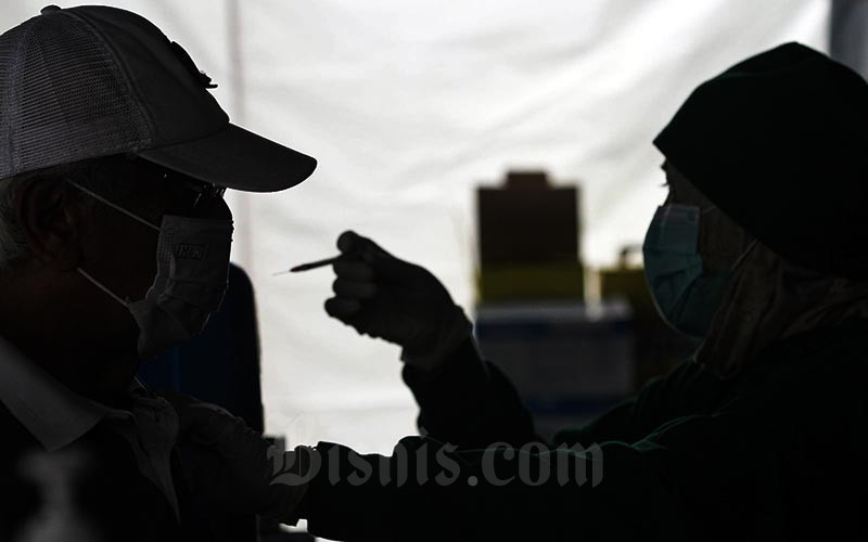 Tenaga kesehatan menyuntikkan cairan vaksin dosis ketiga kepada warga lansia saat vaksinasi booster Covid-19 di Puskesmas Kecamatan Kramat Jati, Jakarta, Rabu (12/1/2021). Bisnis - Arief Hermawan P