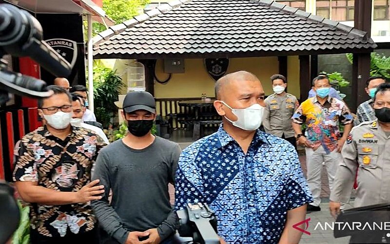 Polisi saat membawa pelaku penendang sesajen untuk menjalani pemeriksaan di Mapolda Jatim, Surabaya, Jumat (14/1/2022). - Antara/Willy Irawan.