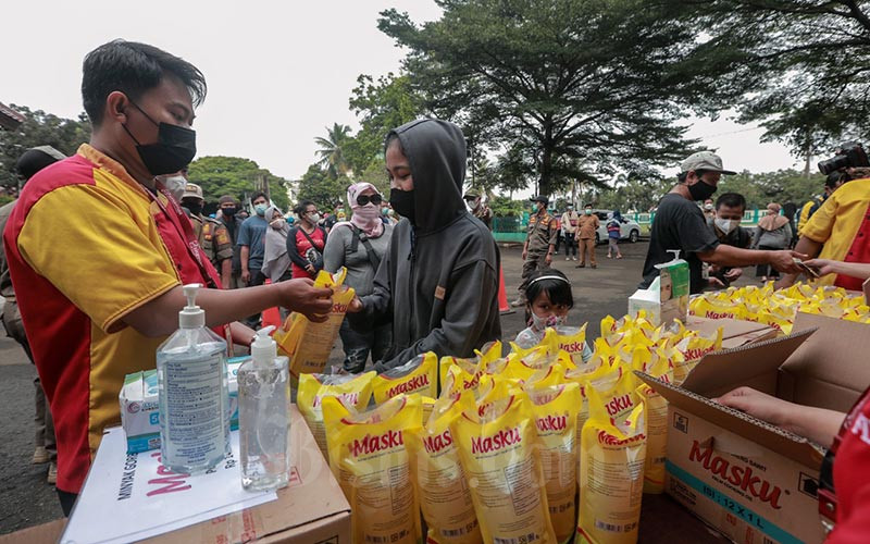 Sejumlah warga antre untuk membeli minyak goreng kemasan saat operasi pasar minyak goreng murah di Halaman Kantor Kecamatan Pamulang, Tangerang Selatan, Banten, Selasa (11/1/2022). Bisnis - Eusebio Chrysnamurti
