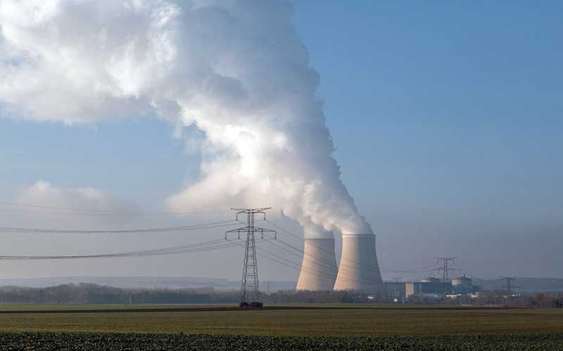 Ilustrasi. Menara pendingin melepaskan uap air di dekat lahan pertanian di pembangkit listrik tenaga nuklir Nogent yang dioperasikan oleh Electricite de France SA (EDF), di Nogent-sur-Seine, Prancis, Selasa (21/12/2021). Bloomberg - Cyril Marcilhacy