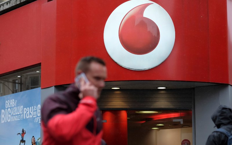 Seorang pria tengah mengangkat telepon di depan gerai Vodafone di London./Simon Dawson - Bloomberg