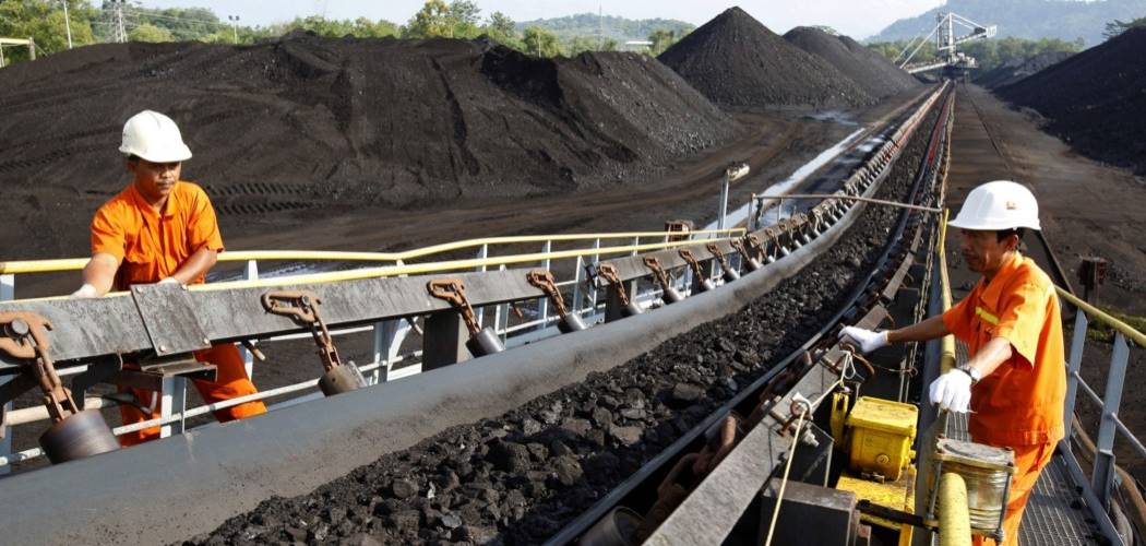 Pekerja melakukan inspeksi pengangkutan batu bara di atas ban berjalan. - Bloomberg / Dadang Tri