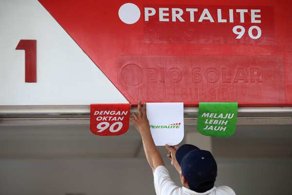 Pekerja menempel gambar informasi tentang BBM jenis Pertalite jelang uji pasar di SPBU Coco, Abdul Muis, Jakarta. - ANTARA