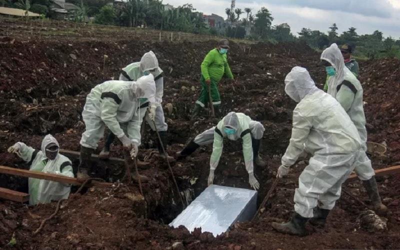 Petugas pemakaman menguburkan jenazah korban Covid-19 di TPU Srengseng Sawah Dua, Jagakarsa, Jakarta Selatan, Selasa, (2/2/2021). - Antara