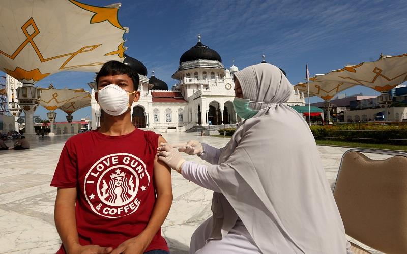 Warga mendapatkan suntikan vaksin Covid-19 oleh petugas kesehatan (kanan) pada vaksinasi merdeka di halaman masjid raya Baiturrahman, Banda Aceh, Aceh, Senin (6/9/2021). Pemerintah mempercepat pelaksanaan vaksin Covid-19 untuk memutus rantai virus corona/ANTARA FOTO  -  Irwansyah Putra