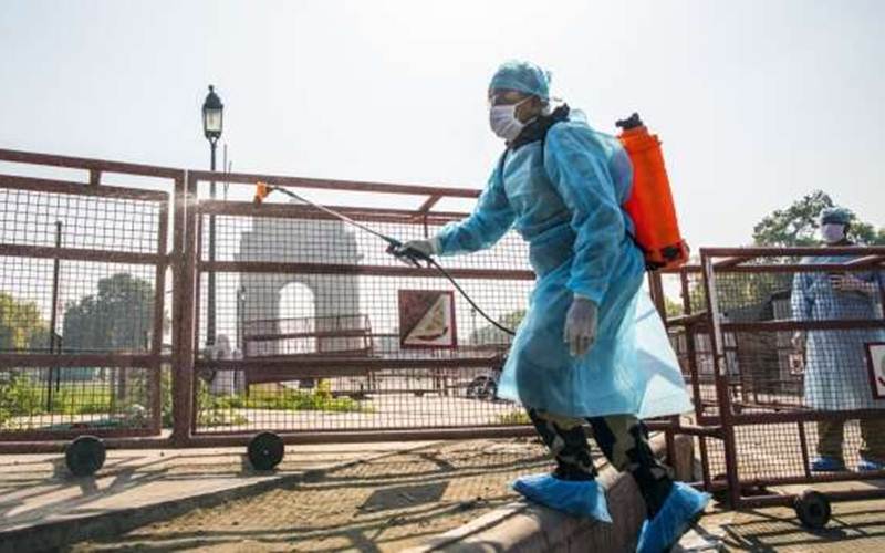 Petugas menyemprotkan disinfektan di dekat monumen India Gate di New Delhi, 22 Maret 2020./Prashanth Vishwanathan - Bloomberg