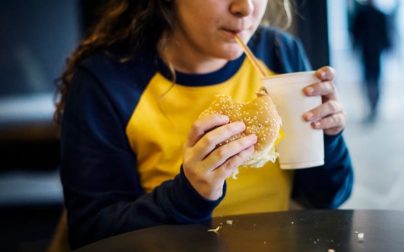 Ilustrasi anak mengonsumsi fast food yang bisa menimbulkan obesitas - Freepik