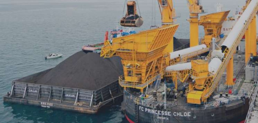 Aktivitas pemindahan muatan batu bara dari tongkang ke kapal induk dengan floating crane oleh anak usaha PT Indika Energy Tbk. (INDY). - indikaenergy.co.id\\r\\n