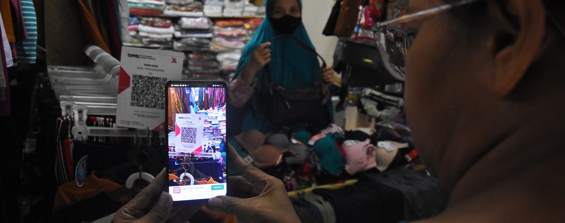 Pembeli bertransaksi nontunai melalui QRIS di Pasar Santa, Jakarta, Senin (6/12/2021).  - Antara