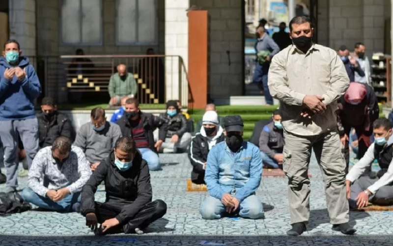 Para pria memakai masker pelindung melakukan ibadah salat Jumat di masjid al-Husseini, saat Yordania mengumumkan peraturan lebih ketat untuk membatasi penyebaran penyakit Covid-19, di Amman, Yordania, Jumat (26/2/2021). - Antara/Reuters\r\n