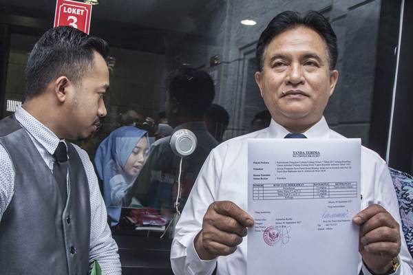 Ketua Umum Partai Bulan Bintang Yusril Ihza Mahendra (kanan) menunjukan berkas tanda terima seusai mengajukan permohonan uji materi UU Pemilu di Mahkamah Konstitusi, Jakarta, Selasa (5/9). - ANTARA/Aprillio Akbar