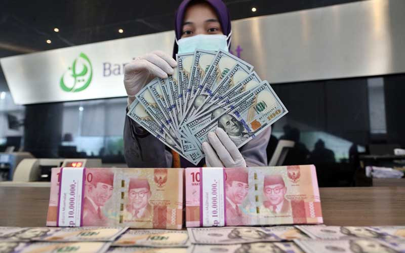 Karyawan menunjukan dolar AS di Jakarta, Rabu (3/3/2021). Bisnis - Eusebio Chrysnamurti