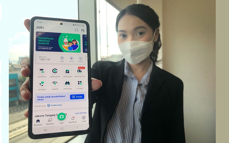 Ilustrasi perempuan memamerkan tampilan aplikasi Jakarta Kini atau JAKI