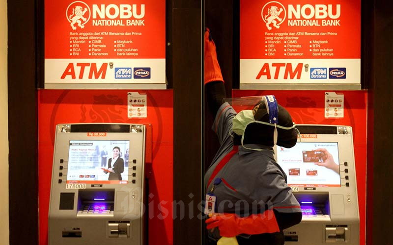 Karyawati melakukan perawatan di salah satu pusat anjungan tunai mandiri (ATM) Nobu Bank di Jakarta.  - Bisnis/Arief Hermawan P