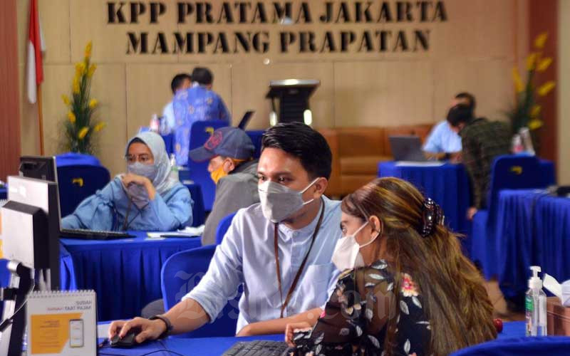 Wajib pajak melaporkan surat pemberitahuan tahunan (SPT) Pajak di Kantor Pajak Pratama (KPP) Mampang Prapatan, Jakarta, Rabu (31/3/2021).  - Bisnis/Fanny Kusumawardhani 