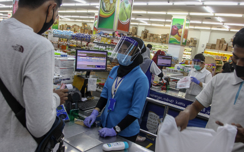 Petugas kasir mengenakan alat pelindung diri berupa masker, face shield, dan sarung tangan ketika melayani pembeli di salah satu gerai penjualan kebutuhan pokok di Mal Pekanbaru, Riau, Selasa (13/10/2020).  - Antara