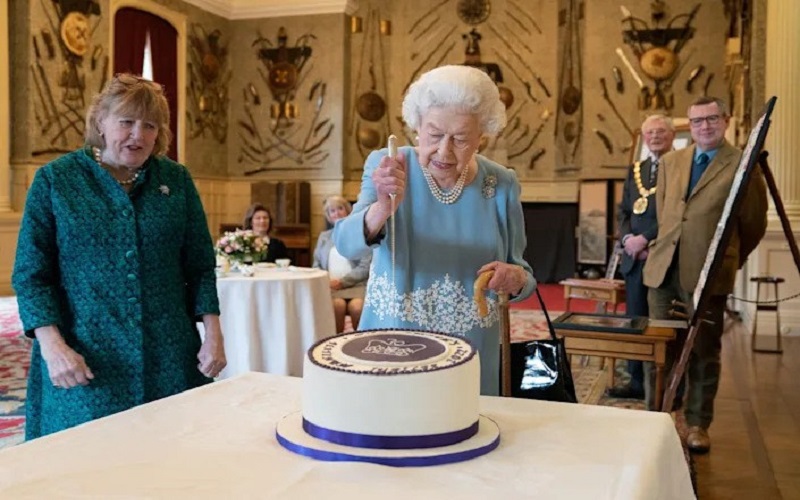 Ratu Elizabeth memotong kue khusus untuk perayaan sebelum Accession Day - Joe Giddens/Getty Images.