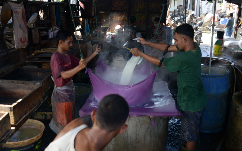 Perajin menuangkan cairan kacang kedelai saat proses produksi tahu di salah satu usaha pabrik di Banda Aceh, Aceh, Kamis (1/10/2020).  - ANTARA FOTO