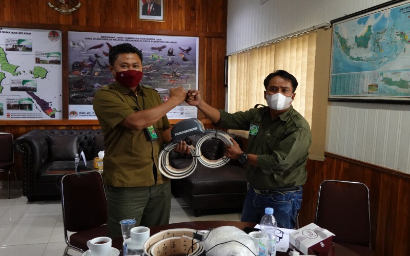 Ketua Perkumpulan Jejaring Hutan dan Satwa (PJHS) Syamsuardi (kanan) sebagai mitra APP Sinar Mas dalam konservasi gajah menyerahkan alat GPS Collar ke perwakilan BKSDA Sumsel di Palembang, Selasa (22/2/22).  - Istimewa