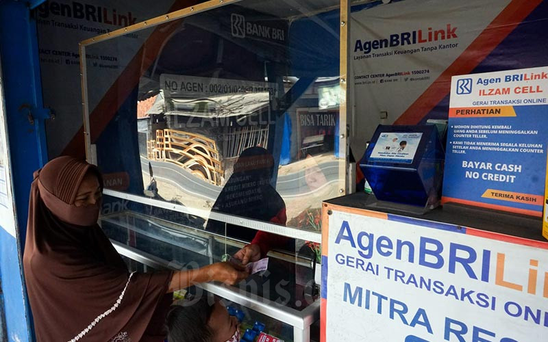 Warga melakukan transaksi di salah satu gerai BRILink di Cibinong, Kabupaten Bogor, Jawa Barat, Minggu (9/1/2021). Bisnis - Suselo Jati