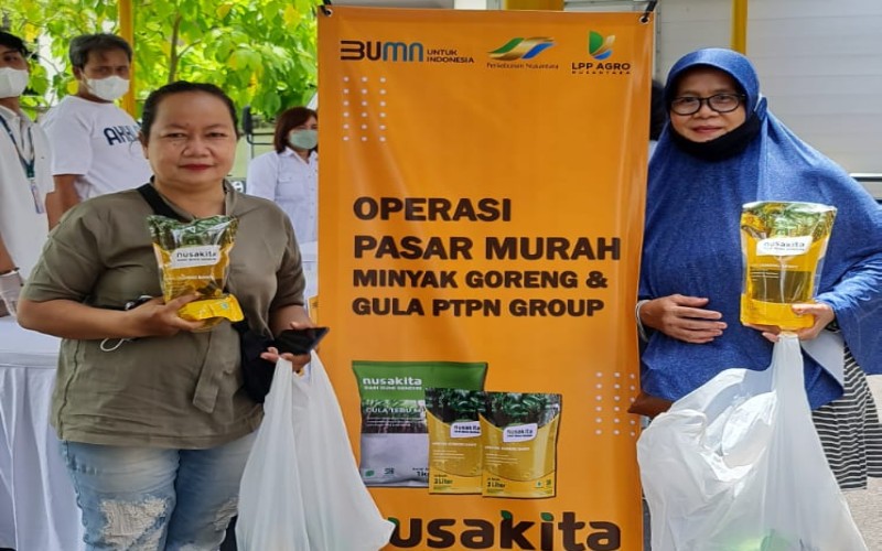 Sejumlah warga berfoto bersama usai mendapatkan minya goreng dalam acara operasi pasar di Yogyakarta. - istimewa