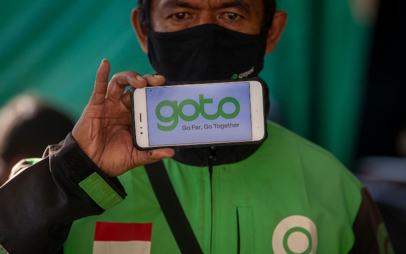 Mitra layanan ojek daring Gojek menunjukkan logo merger perusahaan Gojek dan Tokopedia yang beredar di media sosial di shelter penumpang Stasiun Kereta Api Sudirman, Jakarta, Jumat (28/5/2021). - ANTARA FOTO/Aditya Pradana Putra