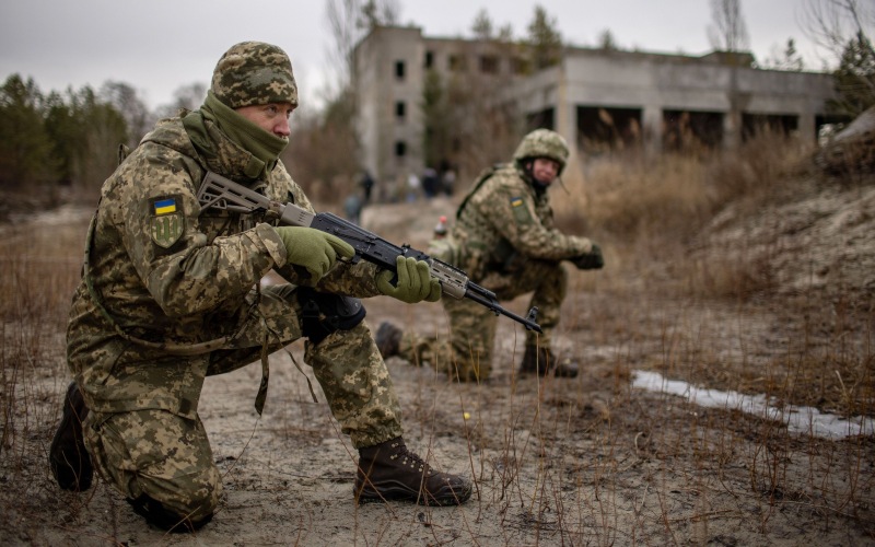 Anggota Pasukan Pertahanan Teritorial Ukraina berpartisipasi dalam latihan di bekas pabrik aspal di pinggiran Kyiv, Ukraina, Sabtu (19/2/2022). - Bloomberg/Ethan Swope