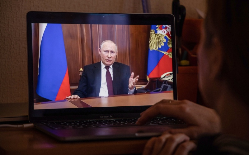 Seorang warga menonton siaran langsung Vladimir Putin, Presiden Rusia, saat menyampaikan pidato, di Moskwa, Rusia, Senin (22/2/2022).  - Bloomberg/Andrey Rudakov