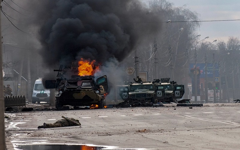 Sebuah pengangkut personel lapis baja Rusia terbakar di tengah kendaraan utilitas ringan yang rusak dan ditinggalkan setelah pertempuran di Kharkiv, Ukraina - Aljazeera/AP