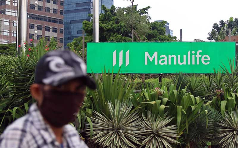 Warga melintas didekat logo perusahaan Manulife Indonesia di Jakarta, Senin (11/5/2020). Bisnis - Eusebio Chrysnamurti