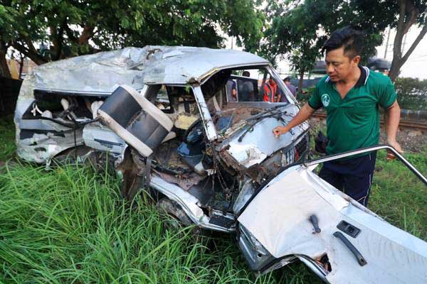 Petugas memeriksa mobil Mitsubishi L300 bernopol P 1264 DE yang ringsek akibat kecelakaan dengan kereta api di lintasan rel di Dusun Rohkepuh, Beji, Pasuruan, Jawa Timur, Rabu (9/1/2019). - ANTARA/Ridwan