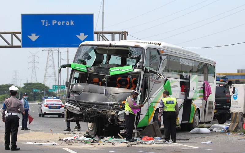 Petugas mengevakuasi bus pariwisata dan truk yang terlibat kecelakaan di Tol Dupak - Tanjung Perak Surabaya, Jawa Timur, Sabtu (5/3/2022). Kecelakaan antara bus pariwisata bernopol D 7610 AT yang memuat rombongan peziarah dengan truk 'Colt Diesel' nomor polisi W 9948 Z itu diduga disebabkan salah satu penumpang bus merebut kendali kemudi dari sopir bus dan menabrak truk 'Colt Diesel' dari arah berlawanan. Dalam kecelakaan itu sopir truk dan kernetnya meninggal dunia di lokasi kecelakaan. - Antara/Didik S.