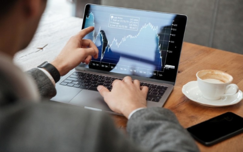 Ilustrasi investor menganalisis pergerakan saham melalui laptop - Freepik.com