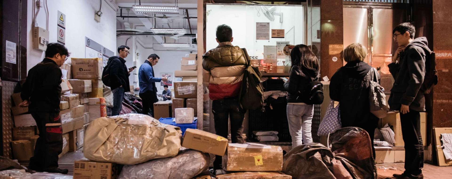 Pelanggan berbaris di salah satu gerai pengiriman logistik di China.  - Bloomberg