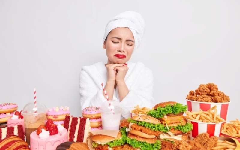 Ilustrasi wanita merasa bersalah akibat makan fast food yang mengandung kolesterol tinggi - Freepik.com