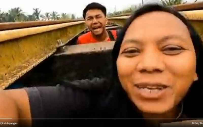 Tangkapan layar video viral Youtuber Dede Inoen buat konten berbahaya dengan bersembunyi di bawah rel kereta api - Youtube